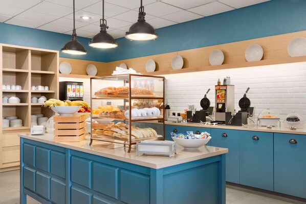 A bakery counter with bread, pastries, and a coffee machine.