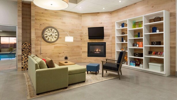 Una sala de estar moderna con un sofá, un sillón y una chimenea.