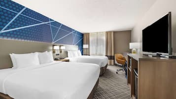 Quarto de hotel com duas camas, uma escrivaninha, televisão e design moderno na parede.