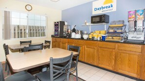 A diner with a breakfast counter, wooden cabinets, and a clock on the wall.
