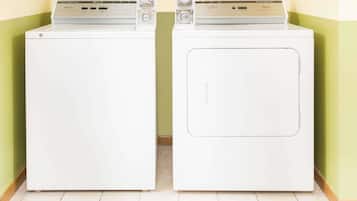 Twee witte voorladers staan naast elkaar in een kamer met groene muren en een betegelde vloer.