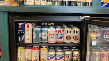 A refrigerated display case with various alcoholic beverages including wine, beer, and mixed drinks.