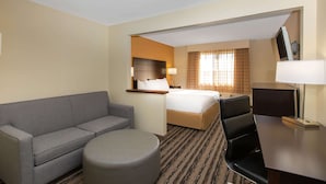 A hotel room with a bed, a sofa, a desk, and a chair. - La Quinta Inn by Wyndham Lincoln, Nebraska (Lincoln)