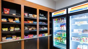 A snack and beverage vending area with various snack brands and a refrigerated drink dispenser. - La Quinta Inn by Wyndham Lincoln, Nebraska (Lincoln)