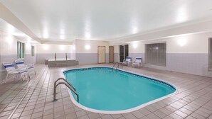 An indoor swimming pool with a tiled floor, a pool ladder, and several lounge chairs. - La Quinta Inn by Wyndham Lincoln, Nebraska (Lincoln)