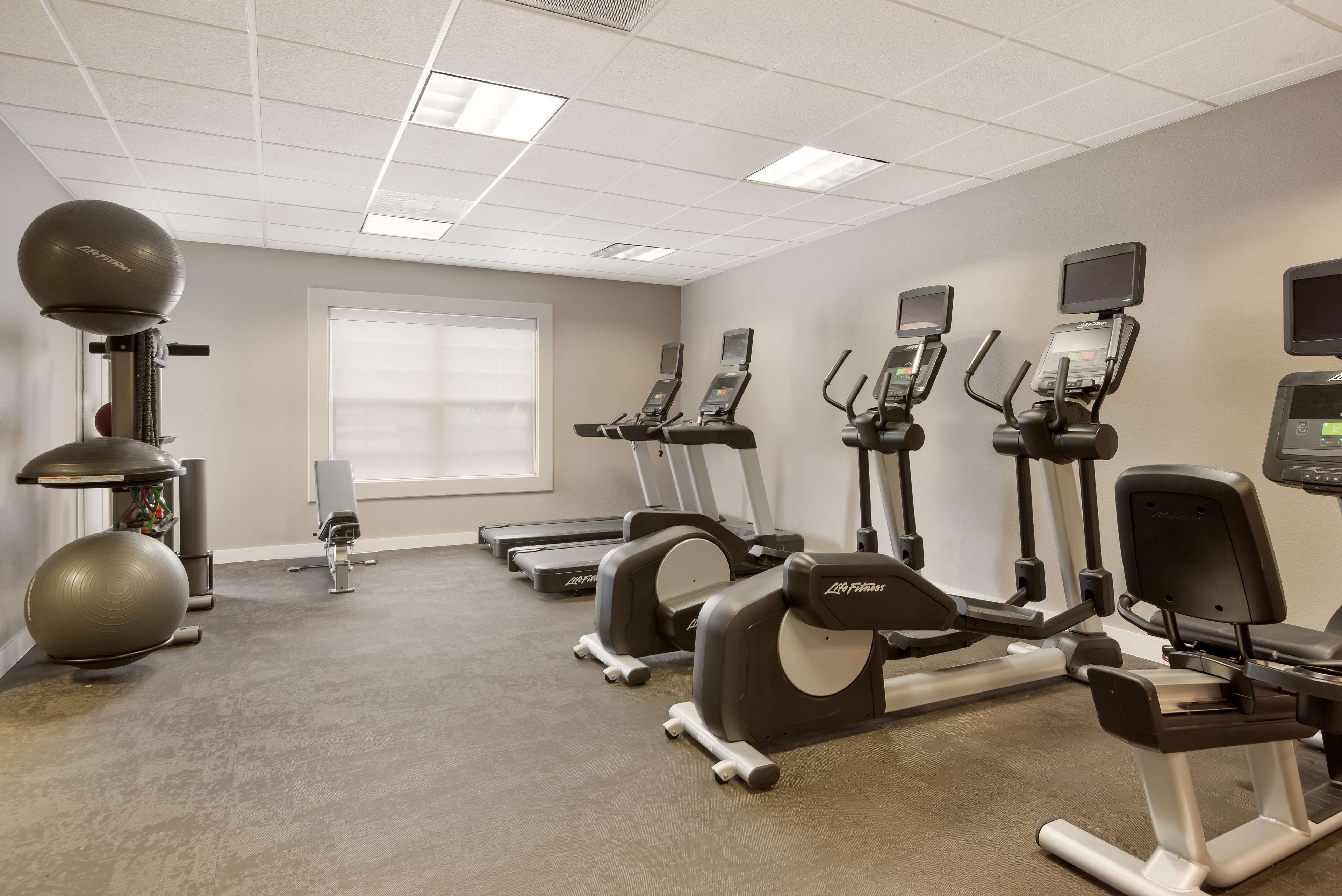 A gym with treadmills, elliptical machines, and a stationary bike.