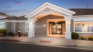 Entrada de un hotel con un letrero que dice "Sonesta ES Suites" y un acceso cubierto.