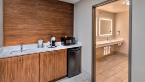 A modern bathroom with a wooden vanity, a sink, a microwave, and a dishwasher. - Holiday Inn Express Winnemucca by IHG (Winnemucca)