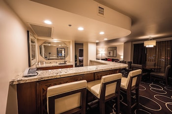 A modern bathroom with a large mirror, a bathtub, a shower, and a vanity with a sink. at Sunset Station Hotel & Casino