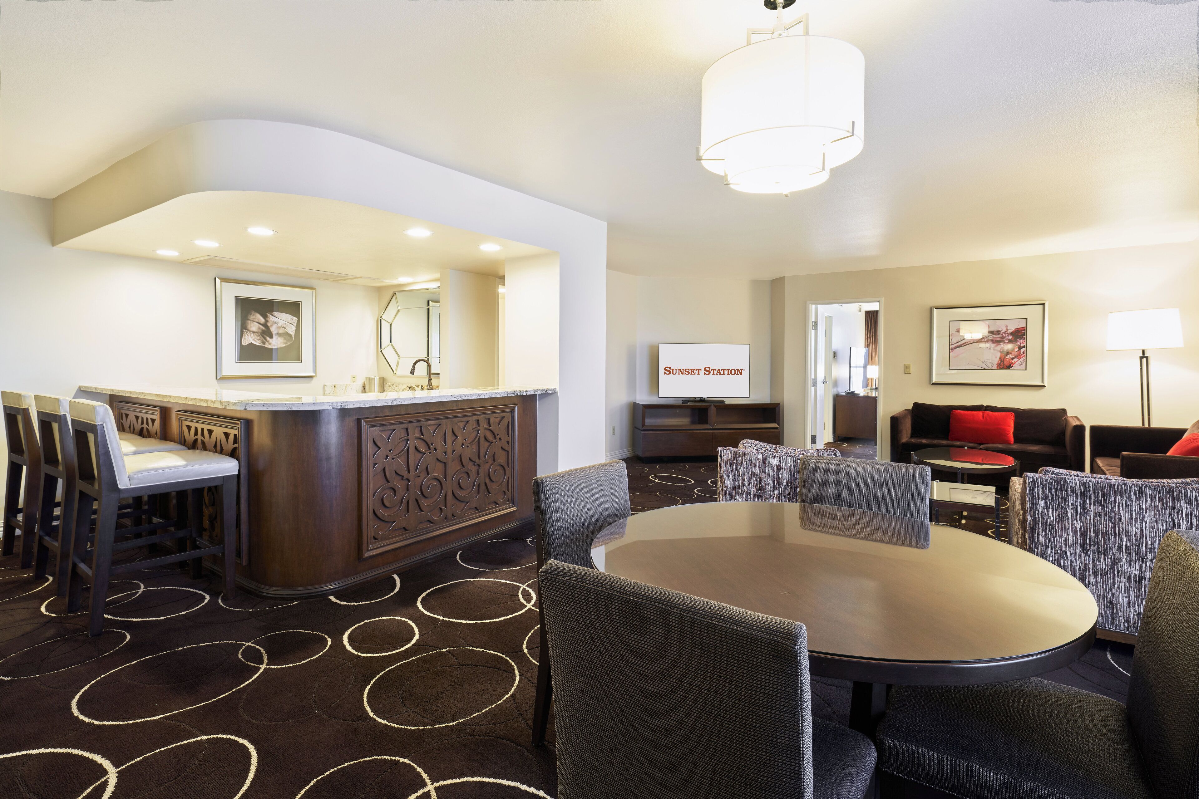 A hotel lobby with a bar, seating area, and artwork on the walls.