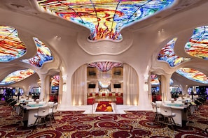 Een luxueus interieur met een bar, zitplaatsen en een opvallend plafondontwerp.