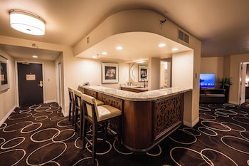 A hotel lobby with a bar area, multiple screens, and a patterned carpet. at Sunset Station Hotel & Casino