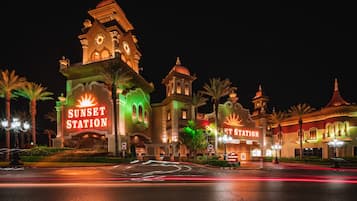 Experience the iconic Sunset Station hotel, featuring a striking clock tower and domes, surrounded by beautifully maintained gardens and palm trees.