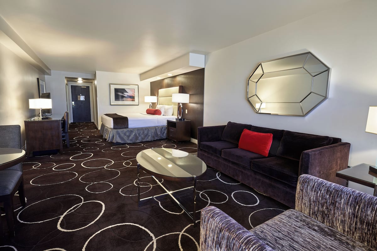 Ein Hotelzimmer mit Bett, Sofa, Couchtisch und Essbereich.
