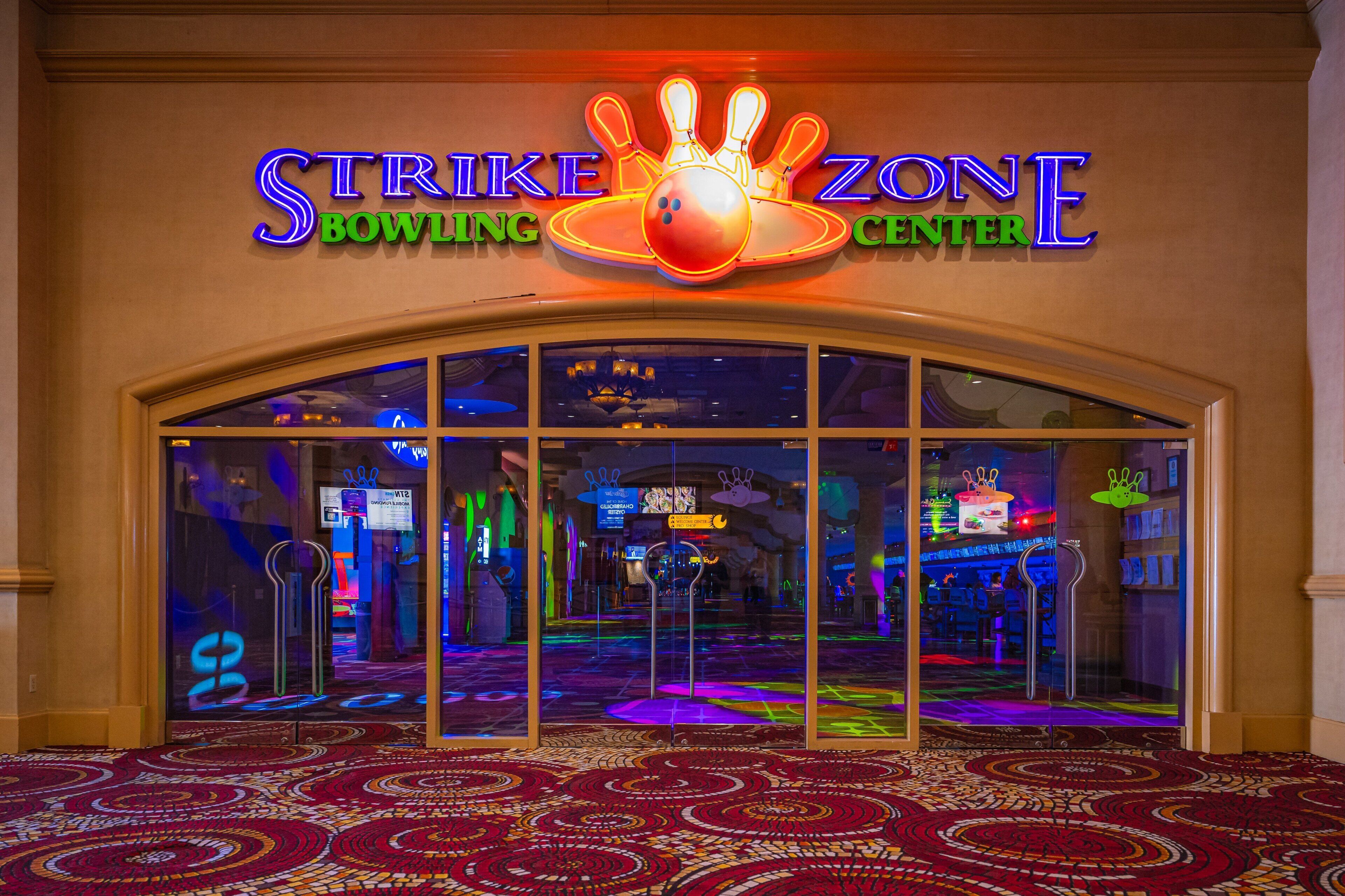 L’entrée du Strike Zone Bowling Center, avec son enseigne au néon, ses portes en verre et son tapis à motifs.