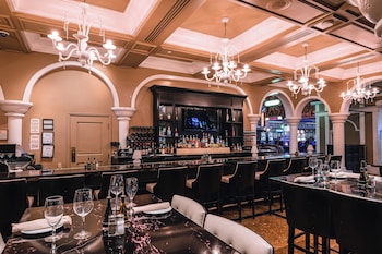 A hotel bar with a marble countertop, bar stools, and a phone. at Sunset Station Hotel & Casino