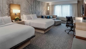 A hotel room with two beds, a desk, a chair, a lamp, and a large window with curtains. - Courtyard by Marriott in Portsmouth (Portsmouth)