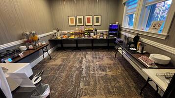 Zona de petit esmorzar d'hotel amb un sistema de buffet, una màquina de cafè i una finestra amb vistes.