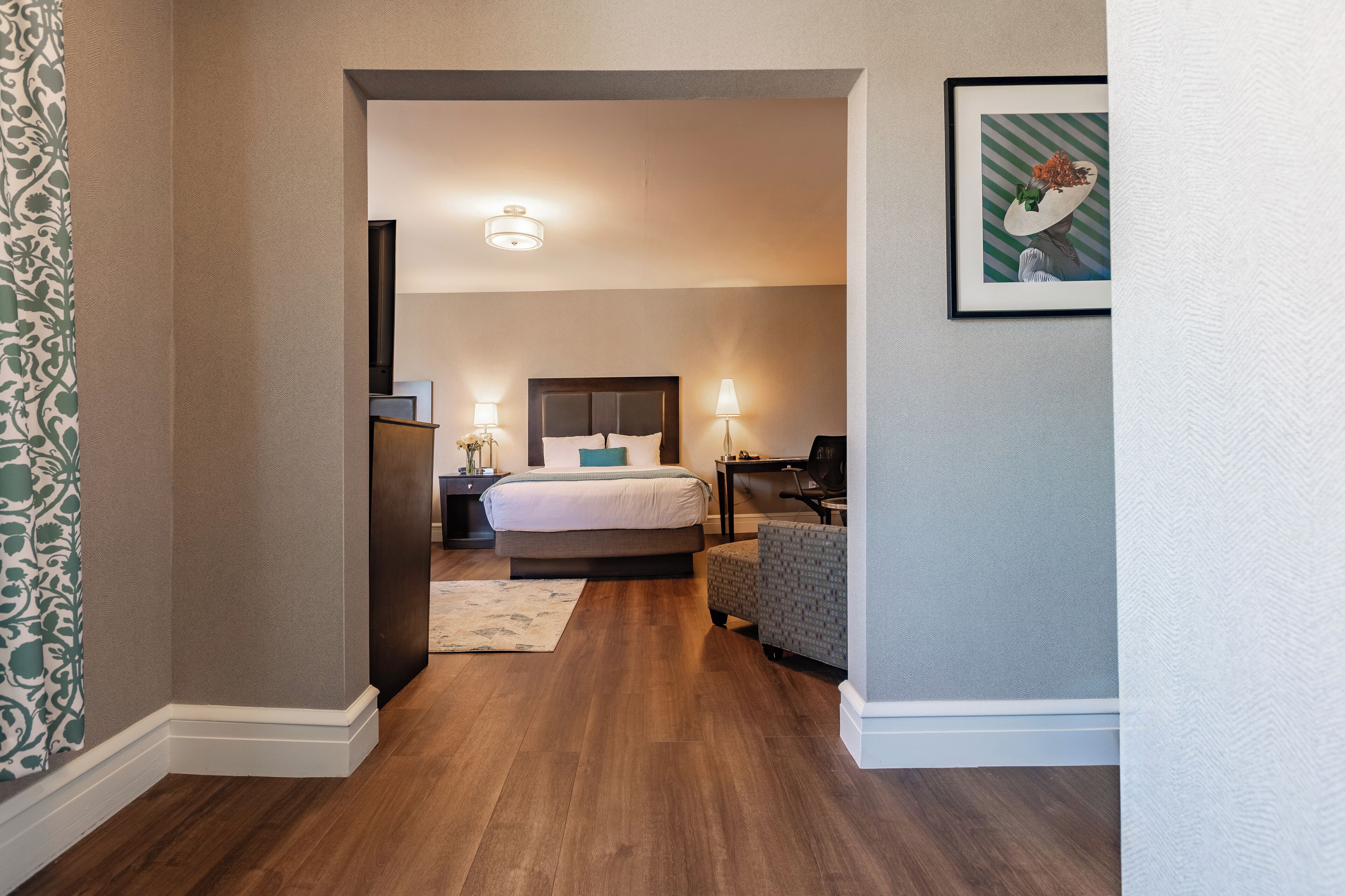 A hotel room with a large bed, bedside tables, a desk, and a chair.