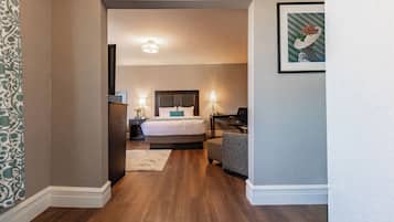 A hotel room with a large bed, bedside tables, a desk, and a chair.