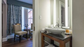 A bathroom with a large sink, mirror, and wooden vanity.
