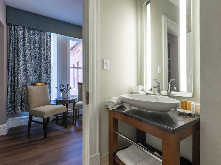 A bathroom with a large sink, mirror, and wooden vanity.
