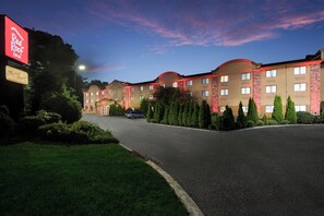 Um hotel com telhado curvo, gramado bem cuidado e céu limpo.