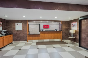 Un área de recepción con mostrador de registro, pantalla digital y un aviso que indica acceso a Wi-Fi gratuito.