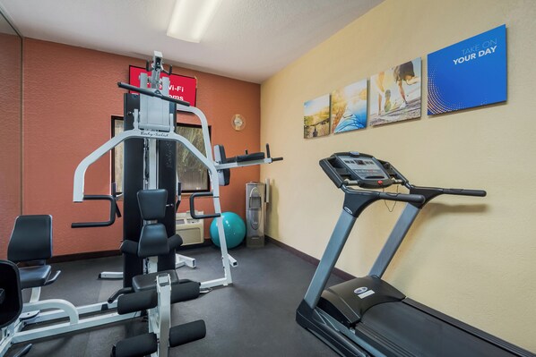 A gym with cardio equipment, weight machines, and exercise balls.