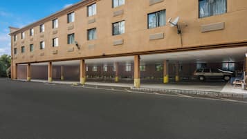 A multi-story hotel with a covered parking area.