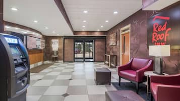 Vestíbulo de Red Roof Inn con un cajero automático, zona de estar y mostrador de recepción.