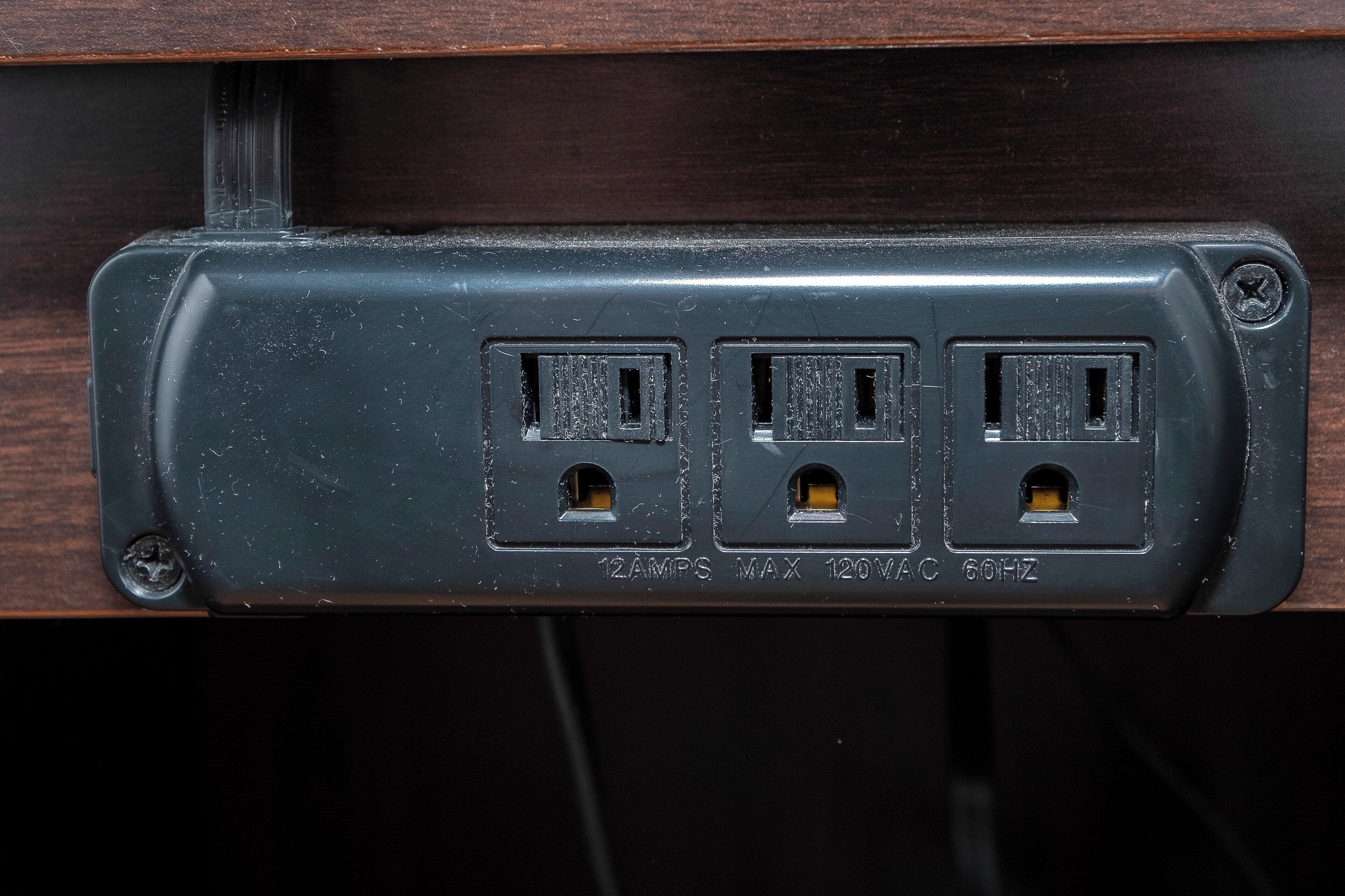 Una regleta con tres enchufes, etiquetada '12Aps Max 120VAC 60Hz'.