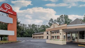 A Red Roof Inn with a large parking lot and a building with multiple rooms. - Red Roof Inn Freehold (Freehold)