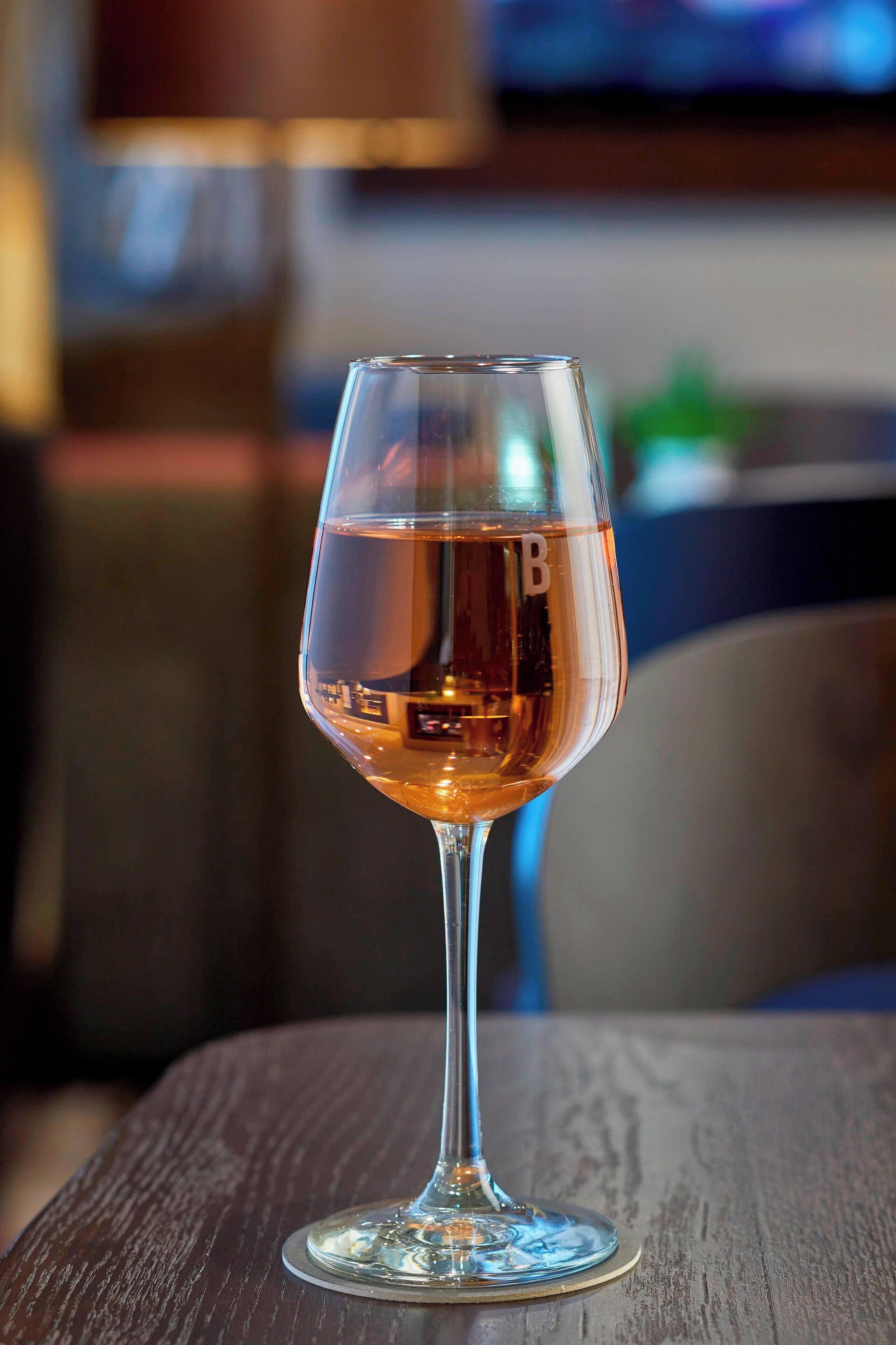 Un verre de vin transparent posé sur une table en bois.