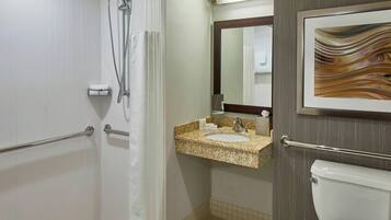 Een badkamer met een douche, wastafel en toilet.