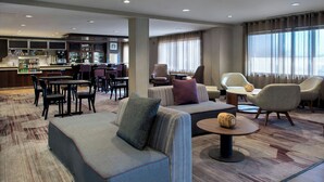 Un hall d’hôtel doté d’un espace salon, d’un bar et offrant une vue sur la ville.