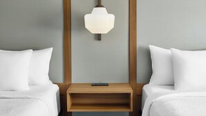 A hotel room with two beds, a wooden nightstand, and a wall-mounted light fixture. - Fairfield Inn by Marriott Rochester East (Webster)