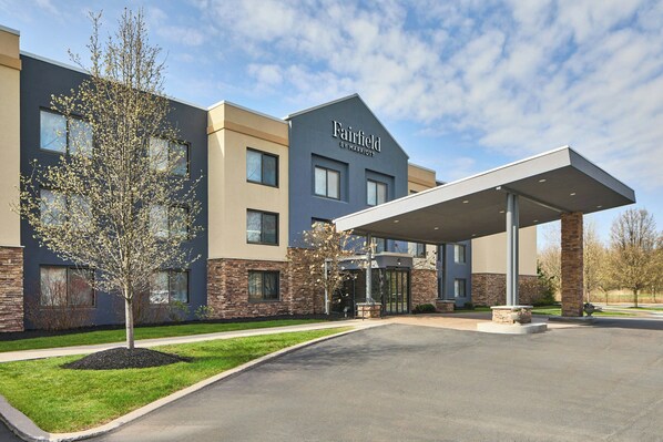 A Fairfield by Marriott hotel with a modern design, featuring a covered entrance and a landscaped area with a tree.