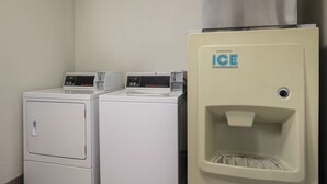A laundry area with two front-loading washers and a water dispenser. - Red Roof Inn Weedsport (Weedsport)