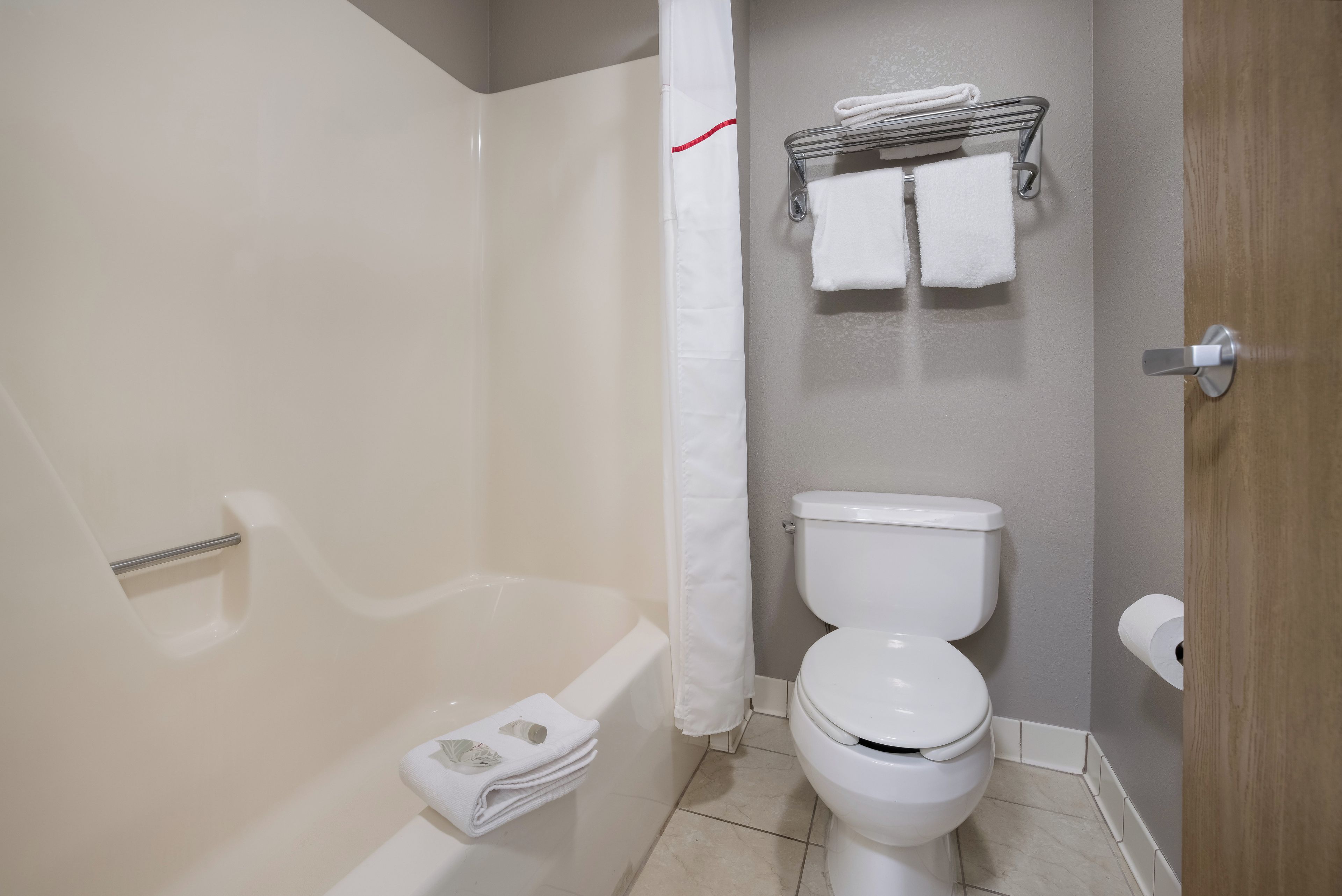 Ein Badezimmer mit Badewanne, Toilette und Handtuchhalter.