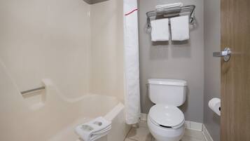 Ein Badezimmer mit Badewanne, Toilette und Handtuchhalter.