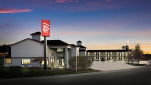 A Red Roof Inn with a large sign, a parking lot, and a building with multiple stories. - Red Roof Inn Weedsport (Weedsport)