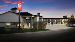 A Red Roof Inn with a modern design, a well-lit entrance, and a parking area.