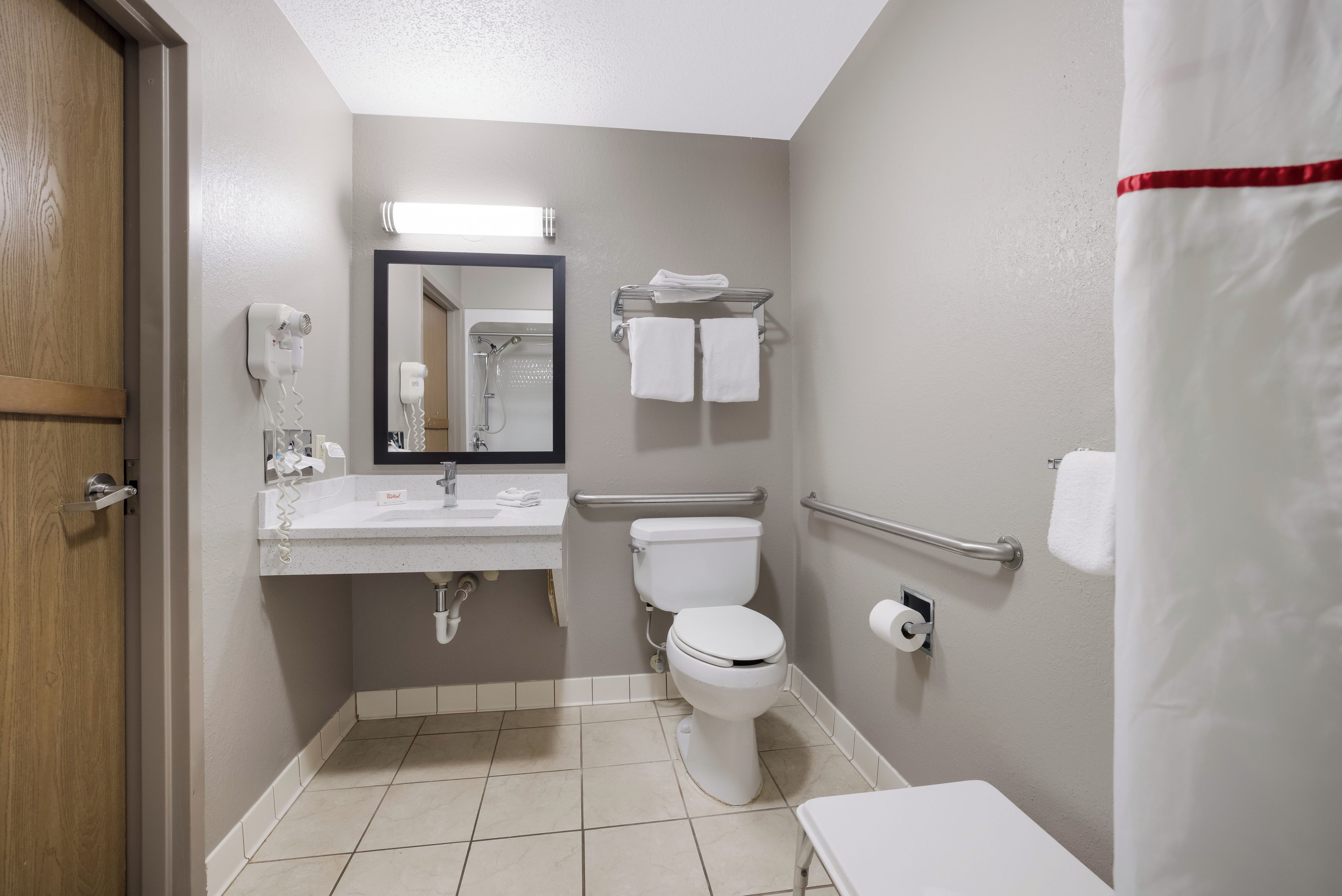 A standard hotel bathroom with a toilet, sink, and shower.