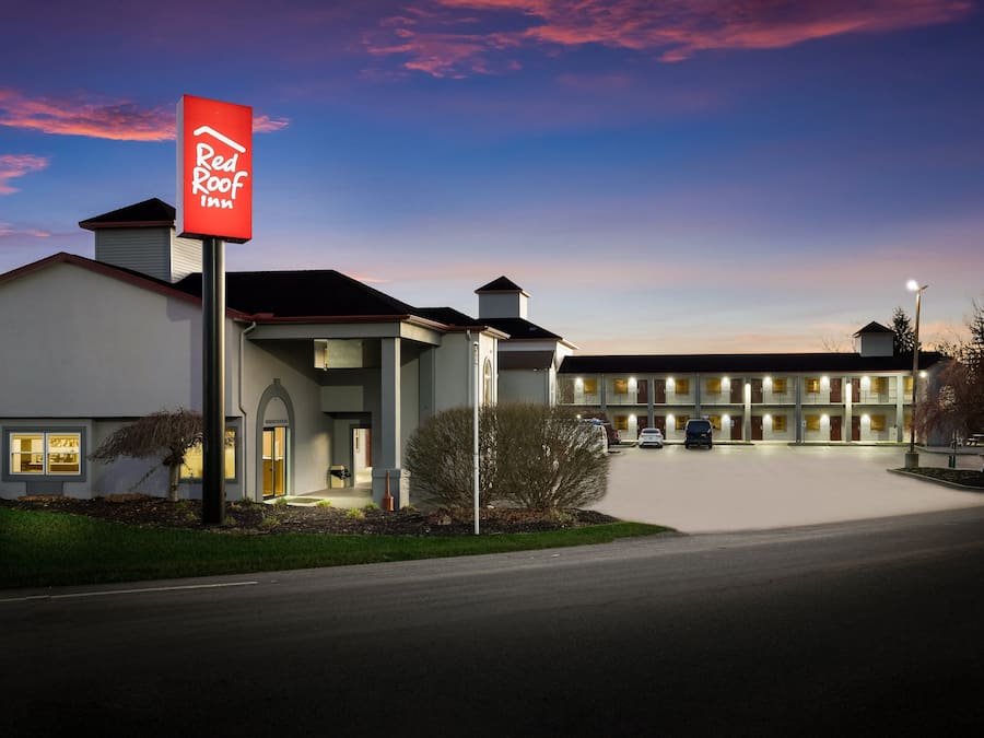 Een Red Roof Inn met een modern design, een goed verlichte entree en een parkeerplaats.