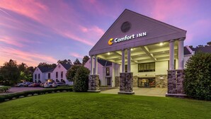 Um hotel Comfort Inn com design moderno, destacando uma entrada imponente e um gramado bem cuidado.