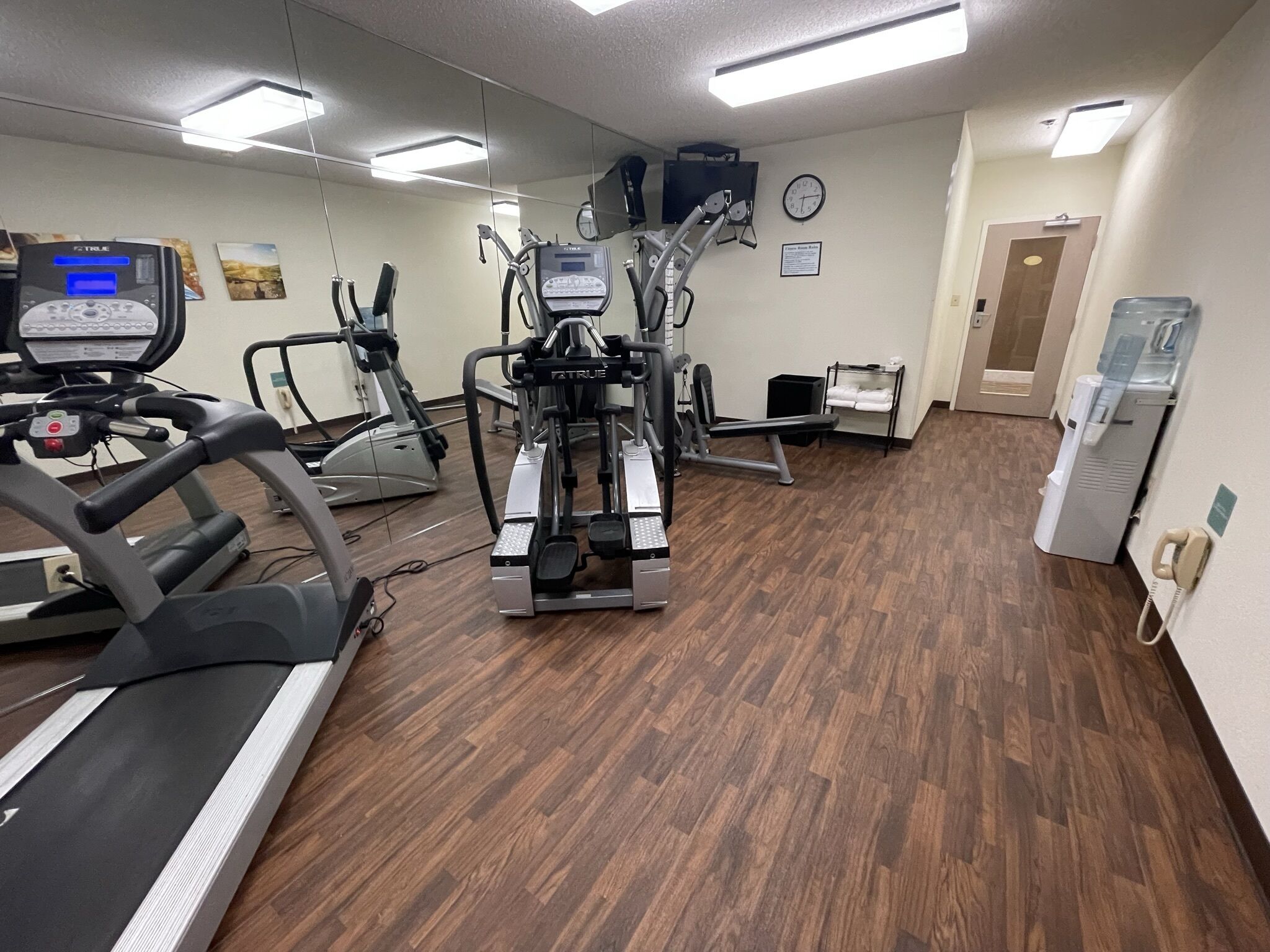 A gym with treadmills, elliptical machines, and a stationary bike.