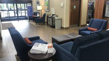 A lobby with seating areas, a reception desk, and a vending machine.
