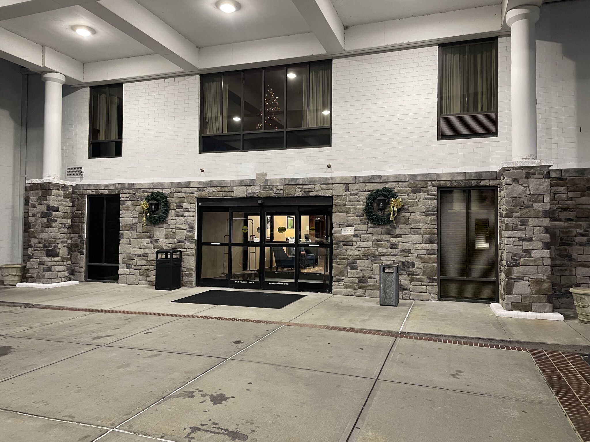 A building with a stone facade, large windows, and a black entrance door.
