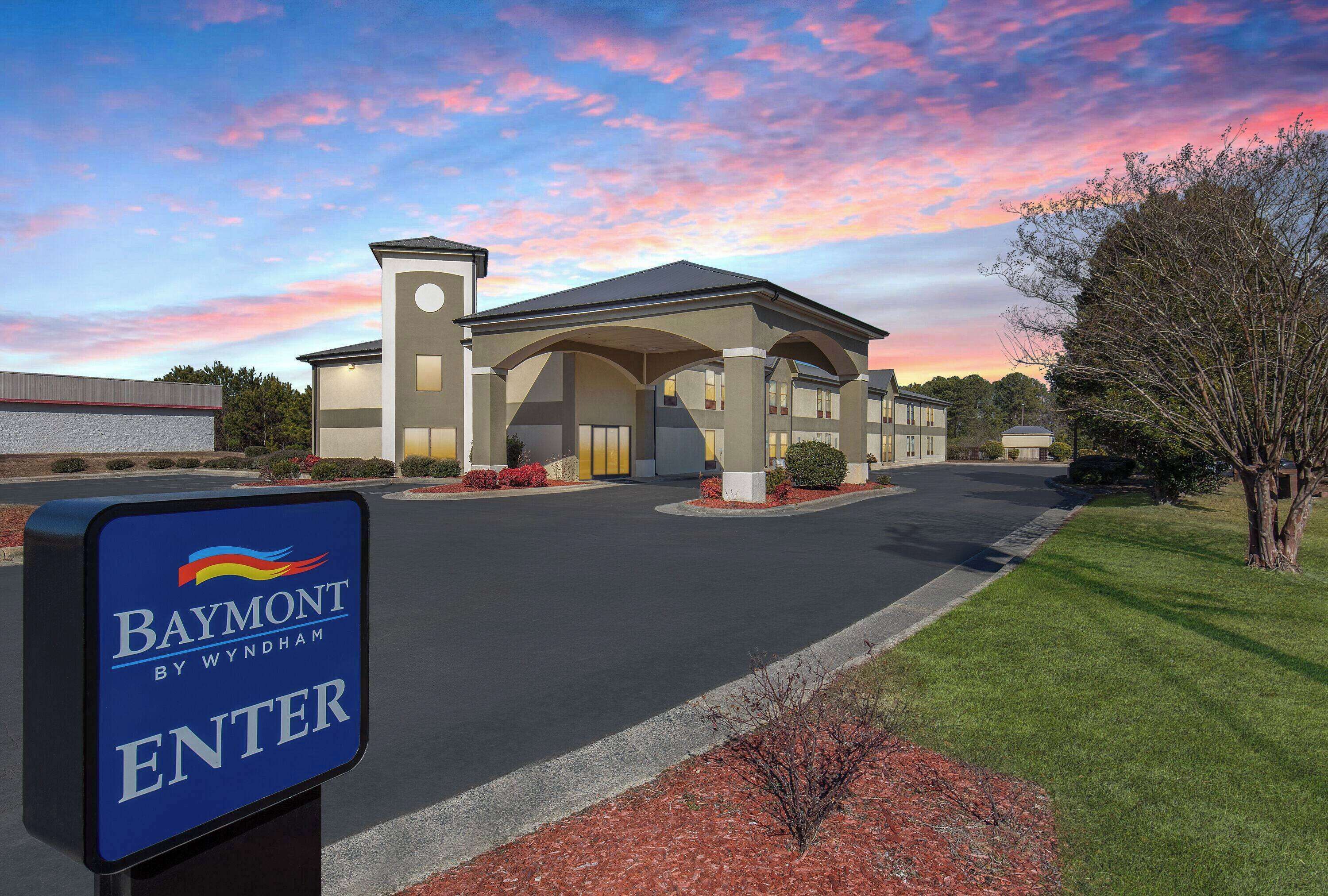 Entrada de hotel con un letrero que dice 'Baymont by Wyndham ENTER'.